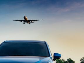 airplane flying over car