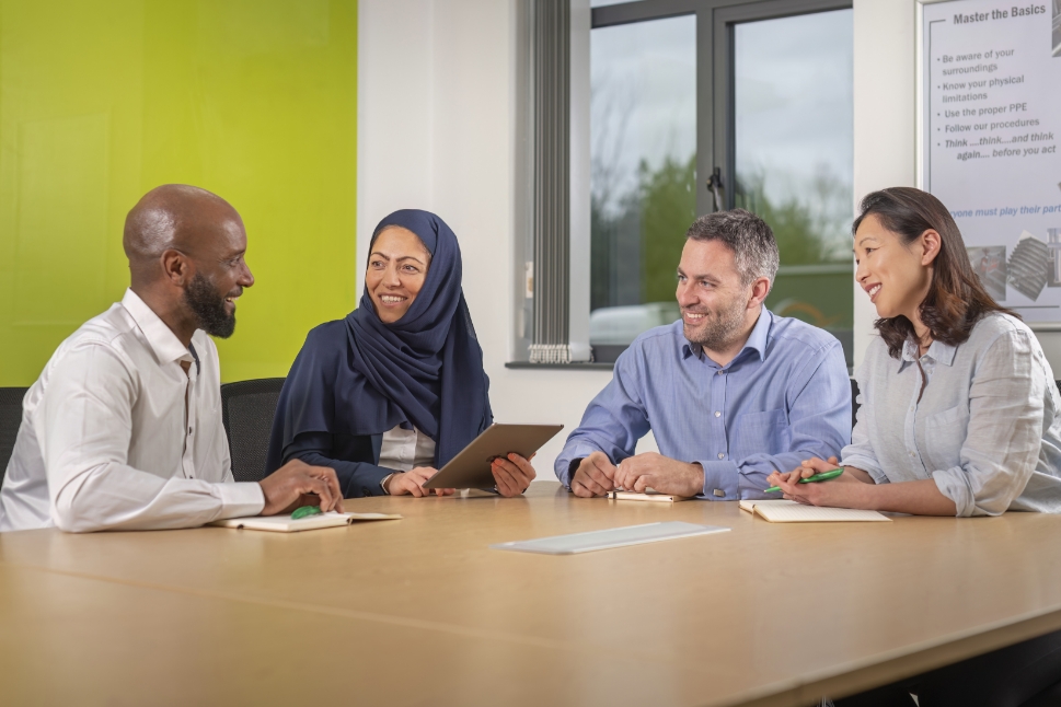 Diverse group of employees sitting around conference table